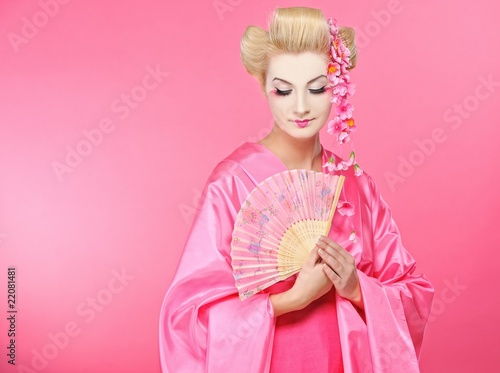 Beautiful geisha with a fan .