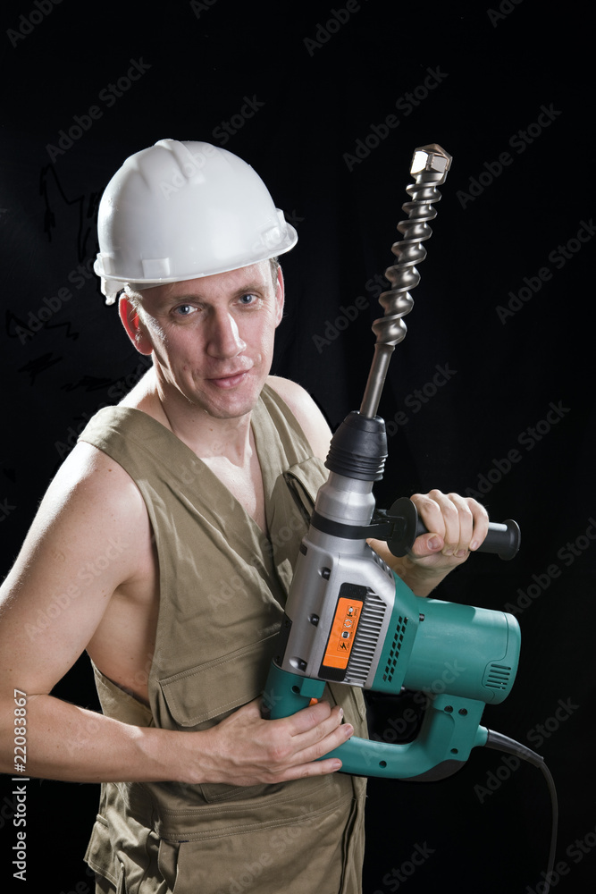 The builder holds the professional puncher-hammer The builder holds the professional puncher-hammer