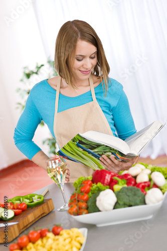 Cooking - Woman reading cookbook in kitchen