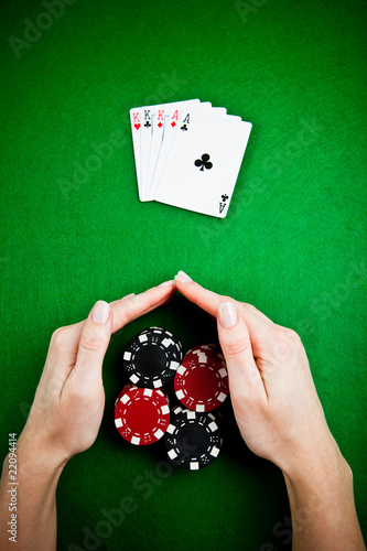 Female hands rakes up stack of gambling chips