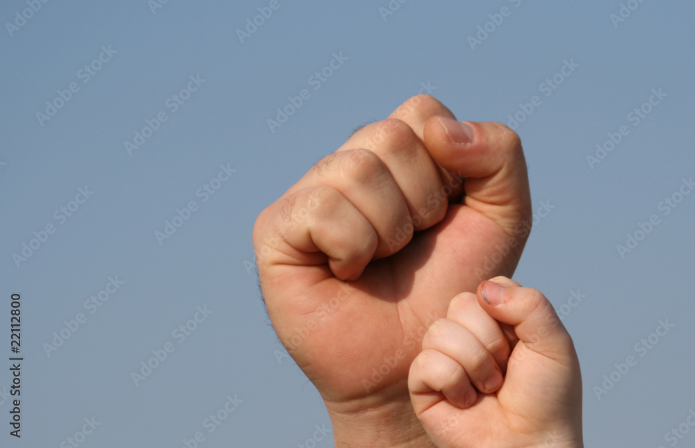 father and son fists on sky background father and son fists on sky background