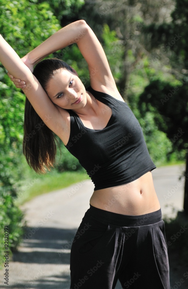 Woman performs stretching before running Woman performs stretching before running