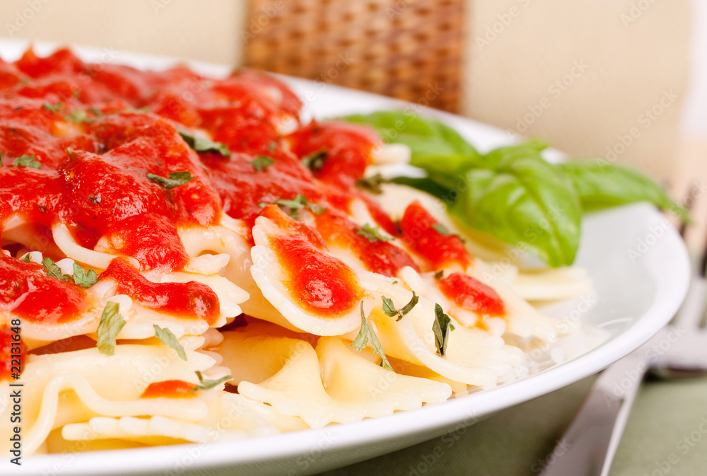 Bowtie pasta with marinara sauce and basil garnish Bowtie pasta with marinara sauce and basil garnish