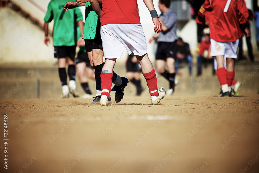 Soccer players on a sand field