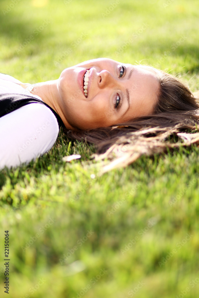 Cute young female lying on grass field at the park . Cute young female lying on grass field at the park .