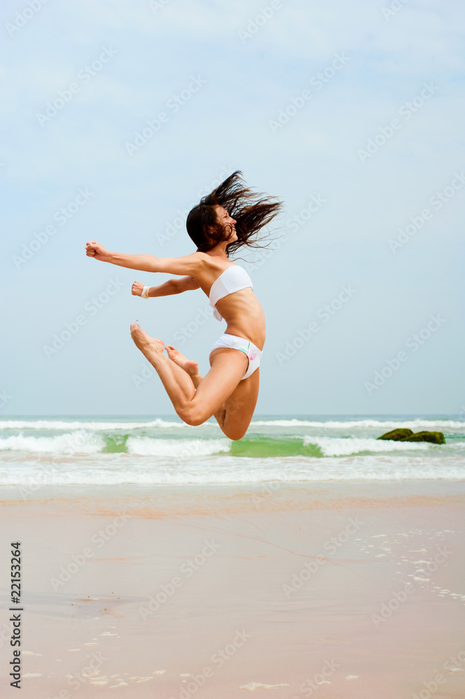 Naklejka premium happy woman jumping on the beach
