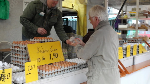Mann kauft Eier am Wochenmarkt