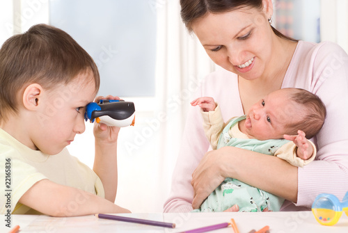 boy looking through binoculars at the newborn