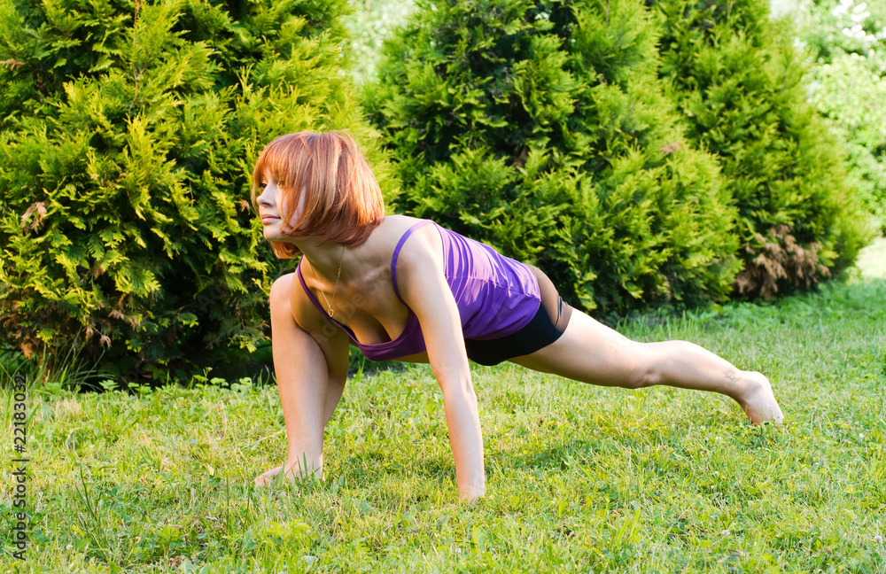 Beautiful red woman doing fitness or yoga exercises Beautiful red woman doing fitness or yoga exercises