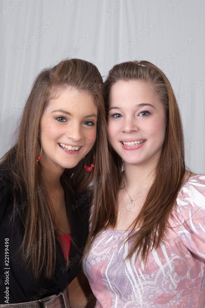Portrait of two smiling teens on white background. Portrait of two smiling teens on white background.