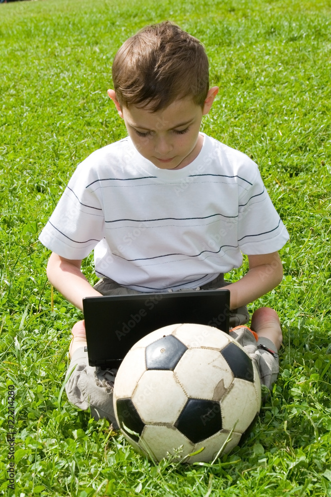 Boy with a laptop on the grass Boy with a laptop on the grass