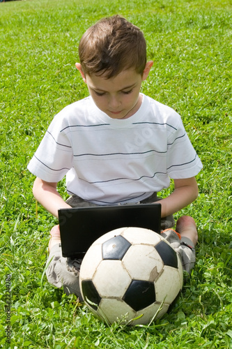 Boy with a laptop on the grass