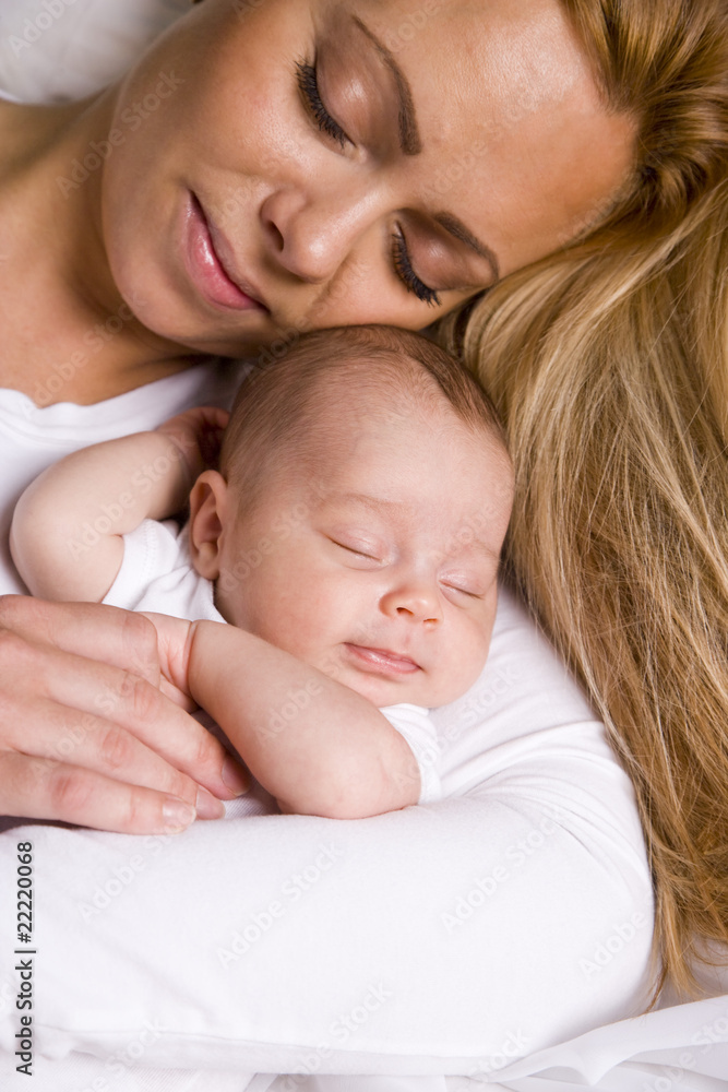 Mother holding baby boy in her arms peacefully asleep Mother holding baby boy in her arms peacefully asleep