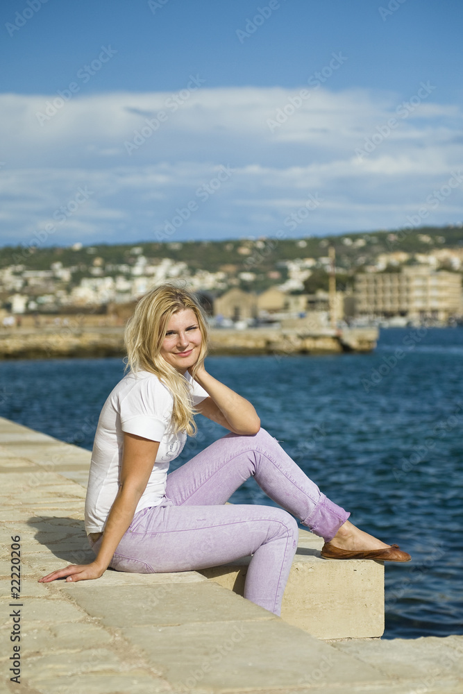 Young beautiful fresh woman smiling and relaxing near sea