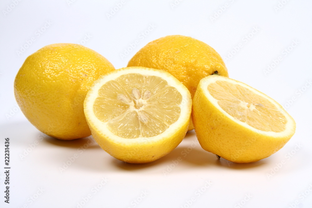 Three lemons, one cut in half, on white background