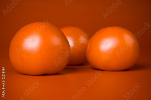 three ripe red tomatoes  on a red background