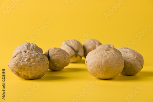 handful of walnuts on a yellow background