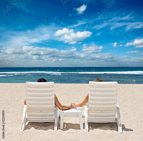 Couple in beach chairs holding hands near ocean © Dmitry Rukhlenko