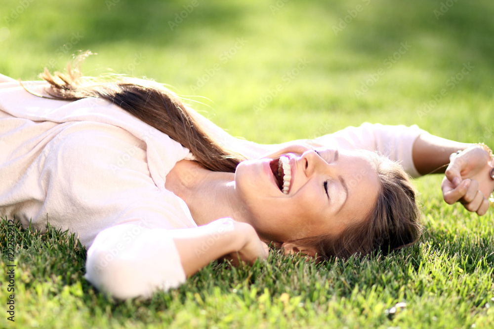Cute young female lying on grass field at the park . Cute young female lying on grass field at the park .