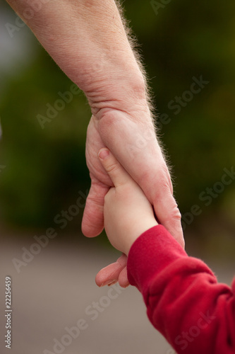 Mature woman holding hands with young child © Scott Van Blarcom