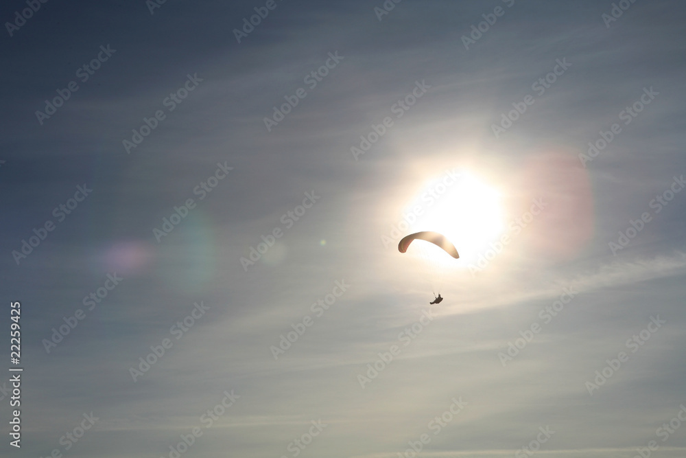 Paraglider in front of the sun