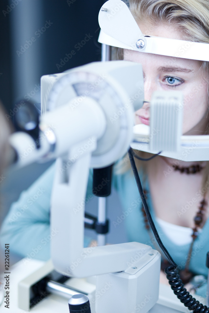 optometry concept - pretty young woman having her eyes examined optometry concept - pretty young woman having her eyes examined