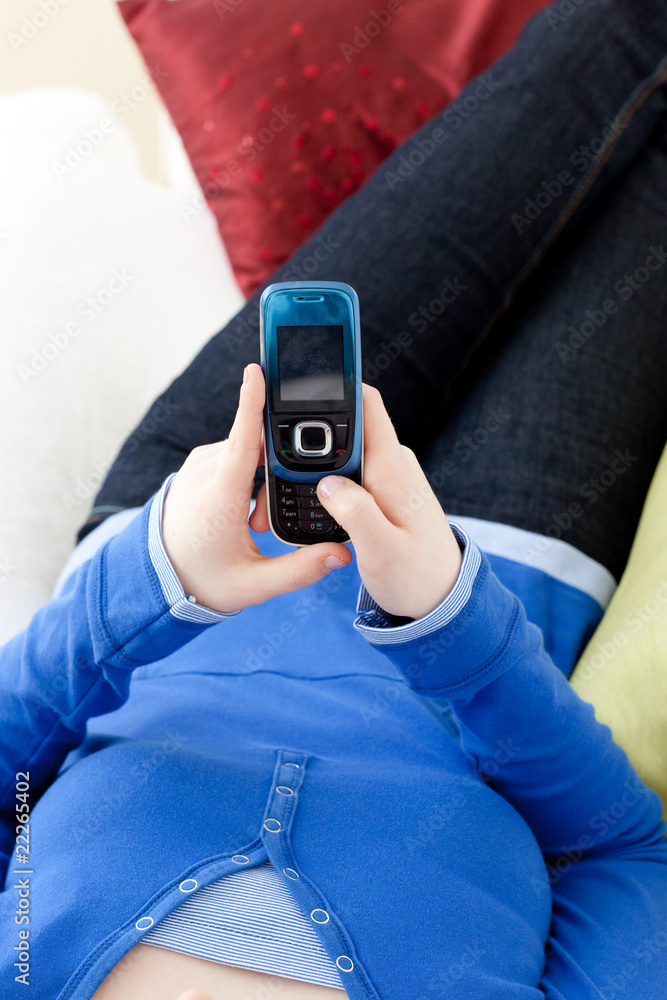 Close-up of a teen girl sending a text lying on a sofa Close-up of a teen girl sending a text lying on a sofa