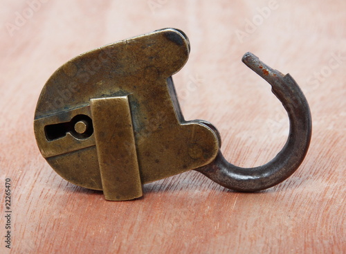 Old brass padlock on wooden background