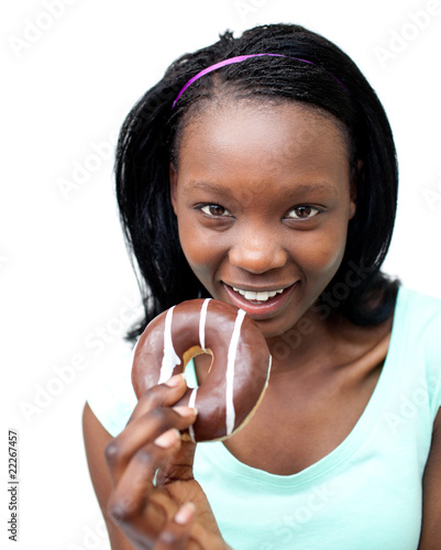 Happy young woman eating a chocolate donut