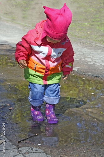 Little Child Standing in Puddle