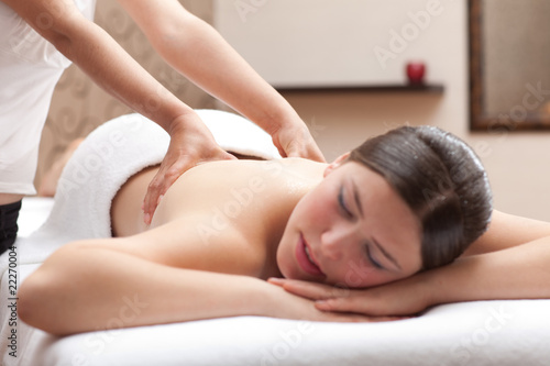 Woman enjoying a back massage in a spa setting