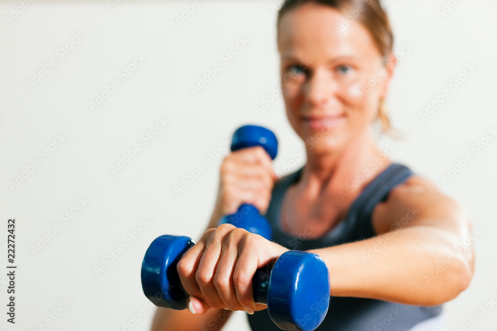 Frau macht Sport mit Hantel im Fitnessstudio Frau macht Sport mit Hantel im Fitnessstudio
