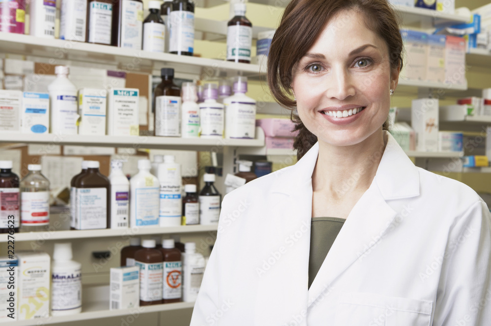 Female pharmacist smiling in pharmacy Female pharmacist smiling in pharmacy