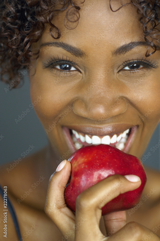 Close up of African woman eating apple StockFoto Adobe Stock