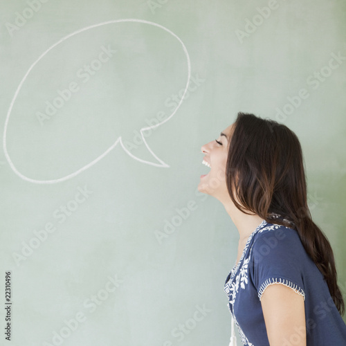 Hispanic woman with speech bubble drawn on blackboard photo