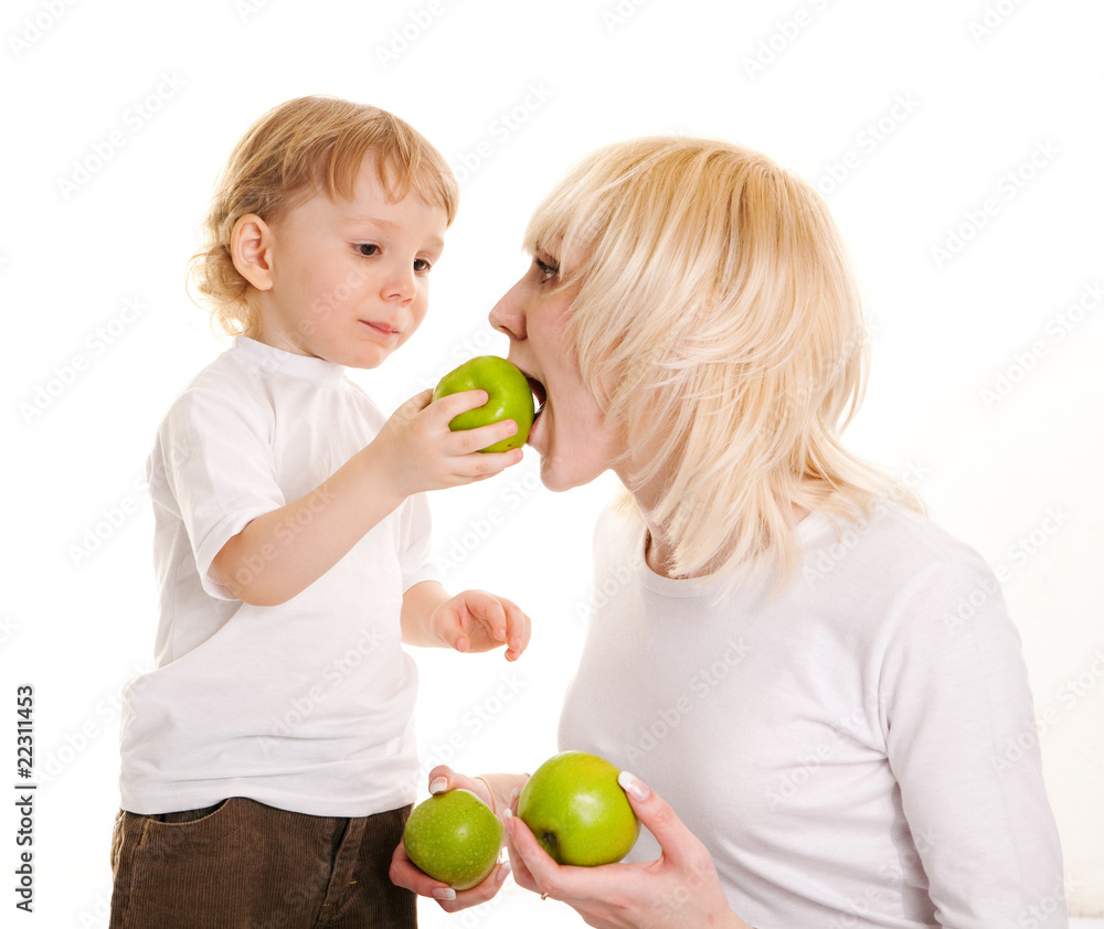 portrait of a young mother and her little son eating apples. portrait of a young mother and her little son eating apples.