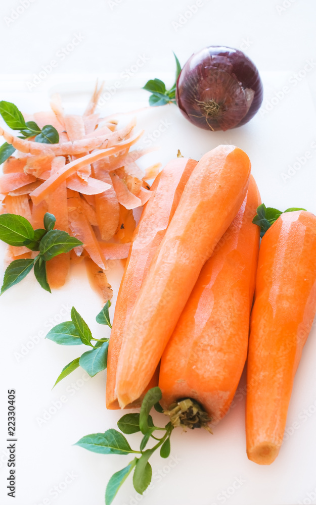 Peeled carrots and onion on white cutting board Peeled carrots and onion on white cutting board