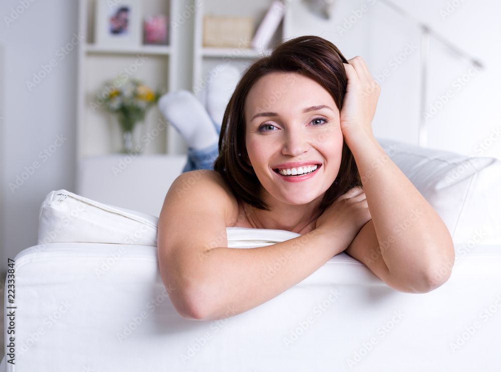 Beautiful smiling happy woman on the sofa at home Beautiful smiling happy woman on the sofa at home