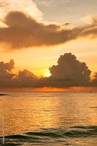 Bright sunrise in early morning with sand beach and ocean photo