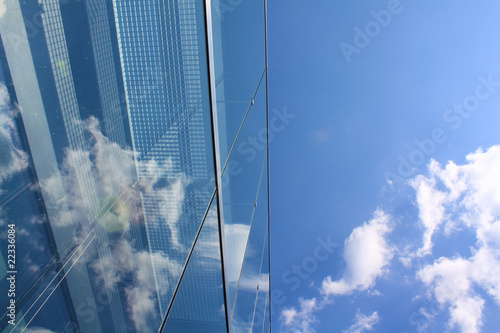 Modern glass office building reflecting the clouds
