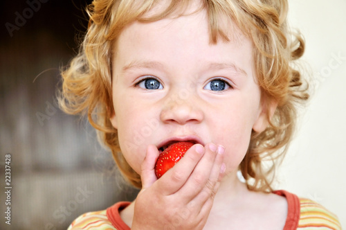 little girl eating strawberry