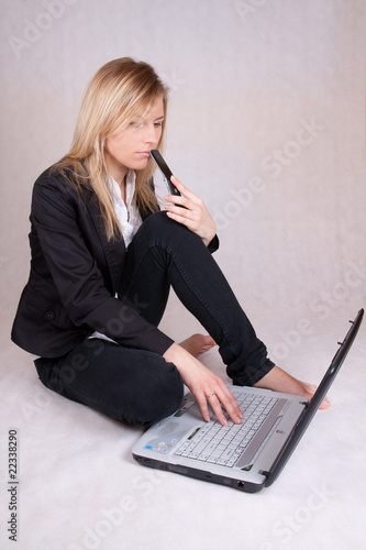Beautiful business woman sitting with laptop and phone
