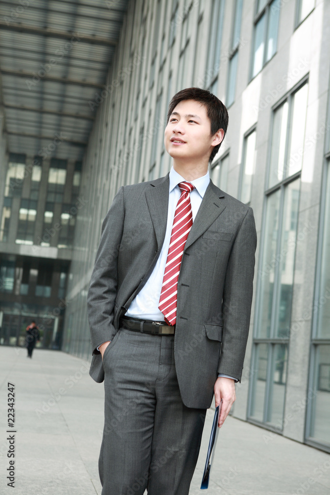 a yong Asiatic businessman is walking outdoor a yong Asiatic businessman is walking outdoor
