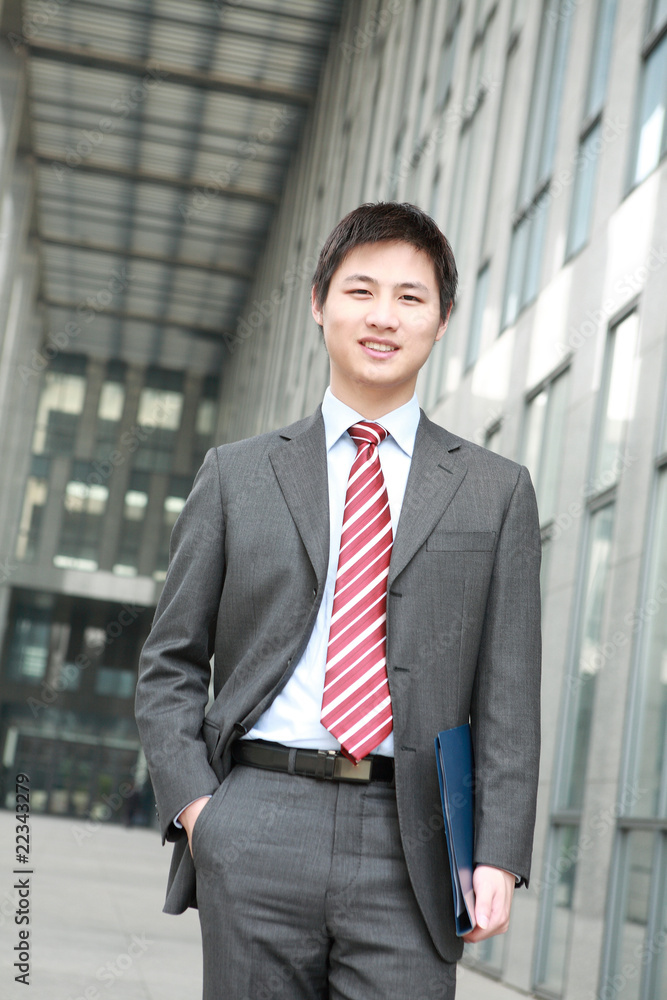 a yong Asiatic businessman is walking outdoor a yong Asiatic businessman is walking outdoor