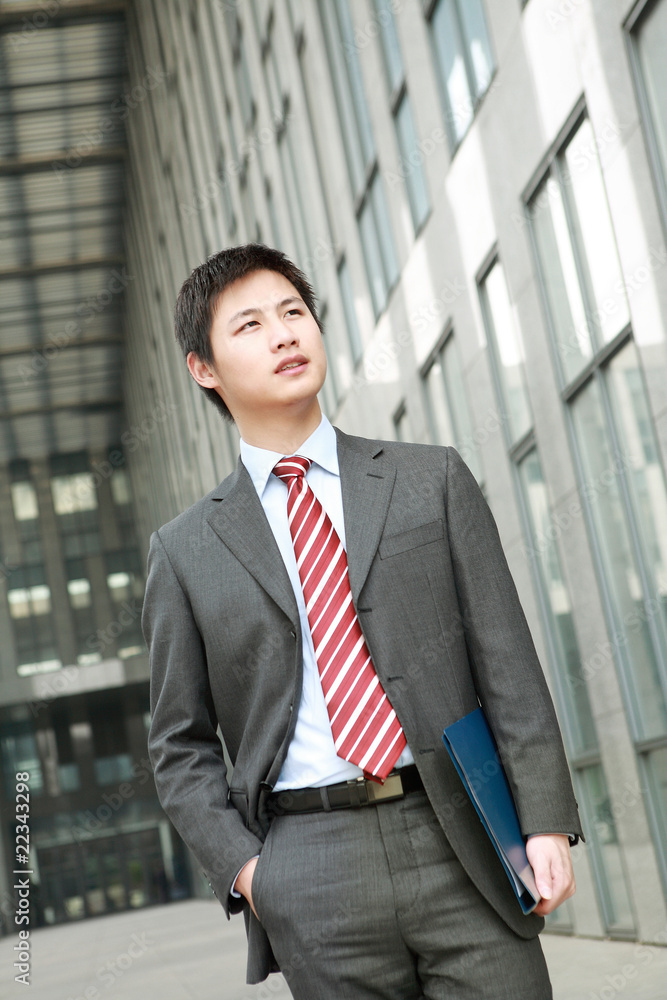a yong Asiatic businessman is walking outdoor a yong Asiatic businessman is walking outdoor