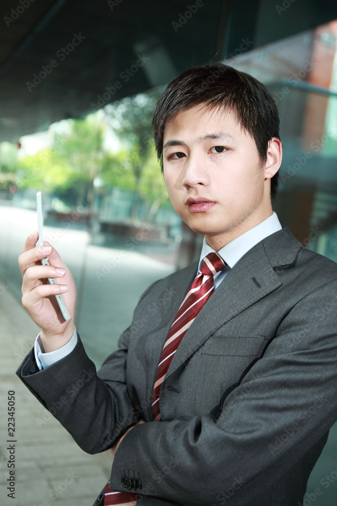 a yong Asiatic businessman is answering phone outdoor at night a yong Asiatic businessman is answering phone outdoor at night