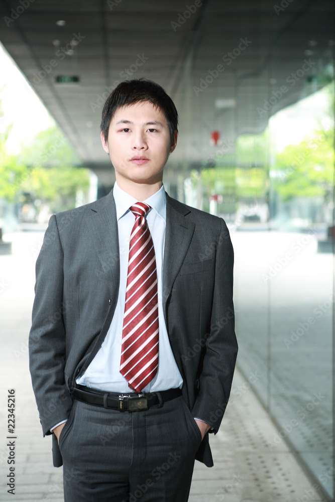 a yong Asiatic businessman is walking outdoor at night a yong Asiatic businessman is walking outdoor at night