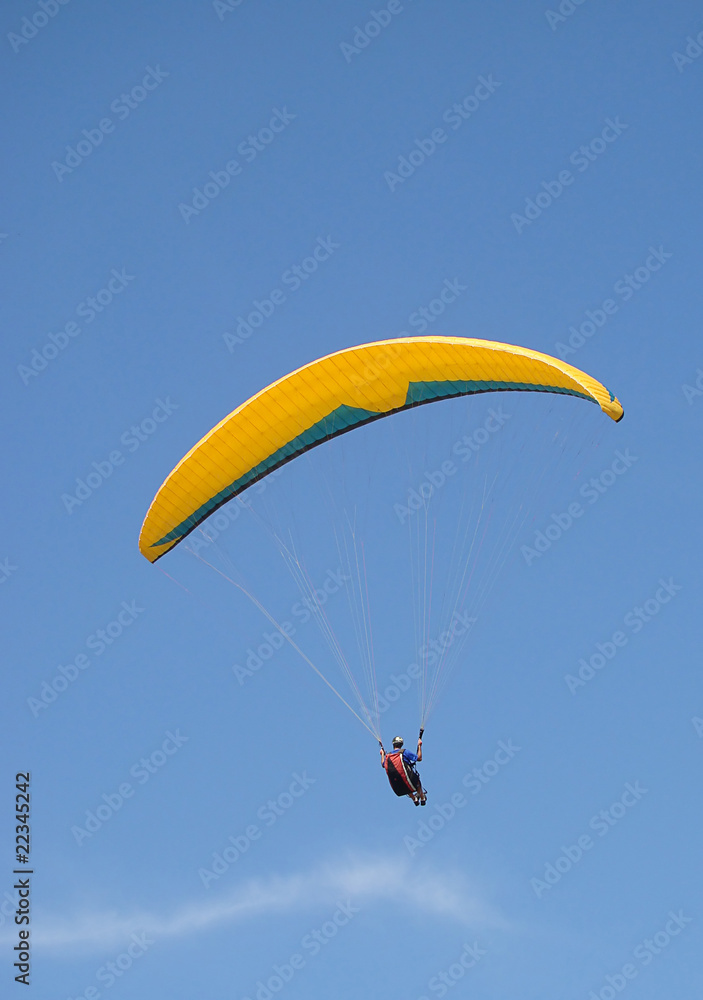 paraglider flying under beautiful blue sky paraglider flying under beautiful blue sky