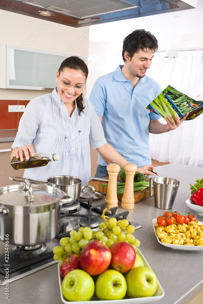 Young happy couple cook in kitchen with cookbook Young happy couple cook in kitchen with cookbook