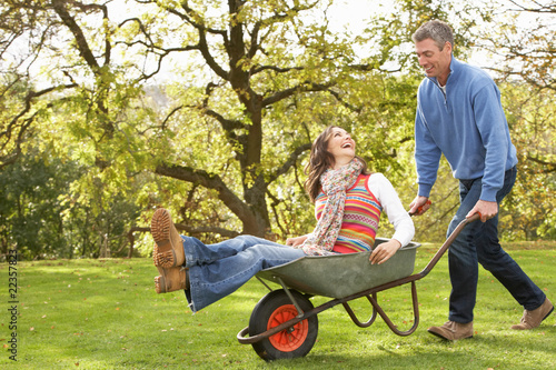 Couple With Man Giving Woman Ride In Wheelbarrow